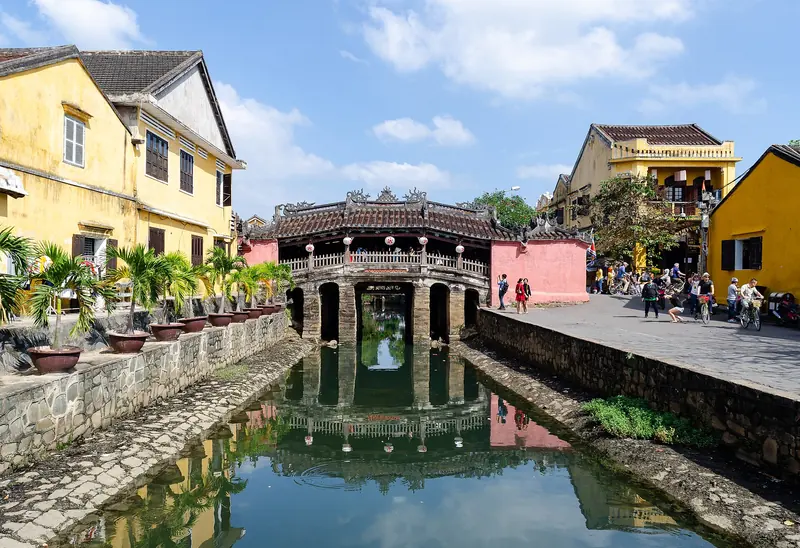 Hội An’s Japanese Covered Bridge with its tiled roof, reflected in the canal